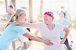 Yoga instructor helping senior woman