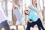 Yoga instructor guiding senior woman in park