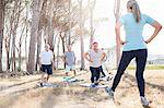 Senior adults practicing yoga in sunny park