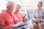 Financial advisor discussing paperwork with senior couple
