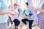 Senior women practicing yoga tree pose in park