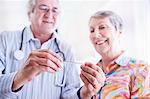 Doctor showing thermometer to senior woman