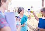 Senior women toasting water bottles after yoga class in park