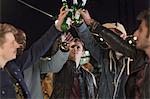 Young men toasting beer bottles at party