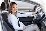 Pregnant woman driving her car, wearing seat belt