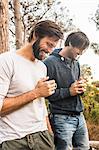 Two men drinking coffee in forest, Deer Park, Cape Town, South Africa