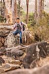 Male hiker hiking down forest rock formation, Deer Park, Cape Town, South Africa