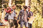 Four male hikers hiking with map in forest, Deer Park, Cape Town, South Africa