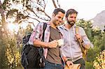 Two male hikers preparing for hike in forest, Deer Park, Cape Town, South Africa