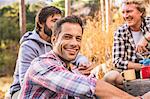 Three men cooking on camping stove in forest, Deer Park, Cape Town, South Africa