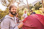 Four men erecting dome tent in forest, Deer Park, Cape Town, South Africa