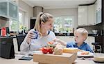 Mother and son sitting at table eating meal together