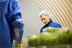 Woman wearing hair net working on production line