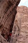 Woman rappelling on rock face, Wadi Rum, Jordan