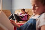 Close up of girl and her sister reading books in living room