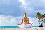 Rear view of young woman practising lotus pose on beach, Dominican Republic, The Caribbean