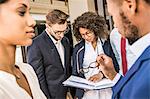 Business team preparing paperwork outside office