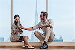 Businesswoman and man sitting at window, Dubai, United Arab Emirates