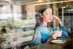 Beautiful woman at cafe window seat, Dubai, United Arab Emirates