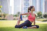 Woman practicing yoga pose in park, Dubai, United Arab Emirates