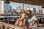 Romantic couple pouring tea at Dubai marina cafe, United Arab Emirates