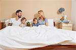 Mother and father in bed with sons and toy dragon