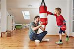 Father holding punchbag for son