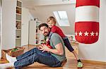 Boy wearing boxing gloves hugging father