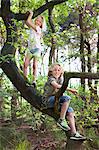 Boy and girl in tree looking at camera smiling