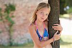 Portrait of girl wearing bikini top leaning against tree, Buonconvento, Tuscany, Italy