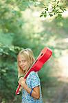 Portrait of girl with red ukulele in woodland, Buonconvento, Tuscany, Italy