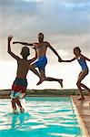 Man jumping into swimming pool with daughter and son, Buonconvento, Tuscany, Italy