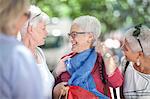 Senior woman and friends chatting in city