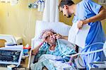 Hospital staff checking on patient on hospital bed