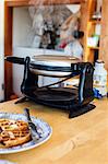 Waffle iron steaming on kitchen counter