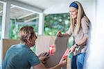 Moving house: couple marking boxes with fragile stickers