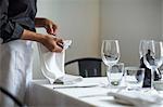 Waitress setting table in restaurant