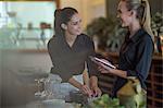 Waitresses chatting and setting table in restaurant