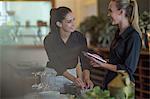 Waitresses chatting and setting table in restaurant