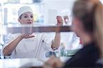 Chef taking orders from waitress in kitchen