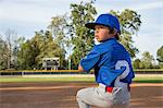 Boy throwing ball at practise on baseball field