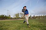 Boy throwing ball at practise on baseball field