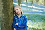 Portrait of girl leaning against tree in bluebell forest, Hallerbos, Brussels, Belgium