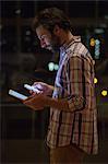 Hipster holding a smartphone and a tablet computer