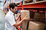 Warehouse manager taking package in shelf