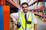 Smiling warehouse manager with yellow coat and scanner