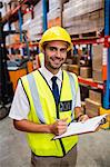 Smiling warehouse manager with clipboard