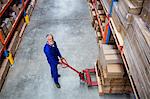 High angle view of man worker smiling with the pallet truck