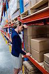 Portrait of exhausted warehouse manager`leaning on a box