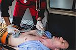 Ambulance man using defibrillator